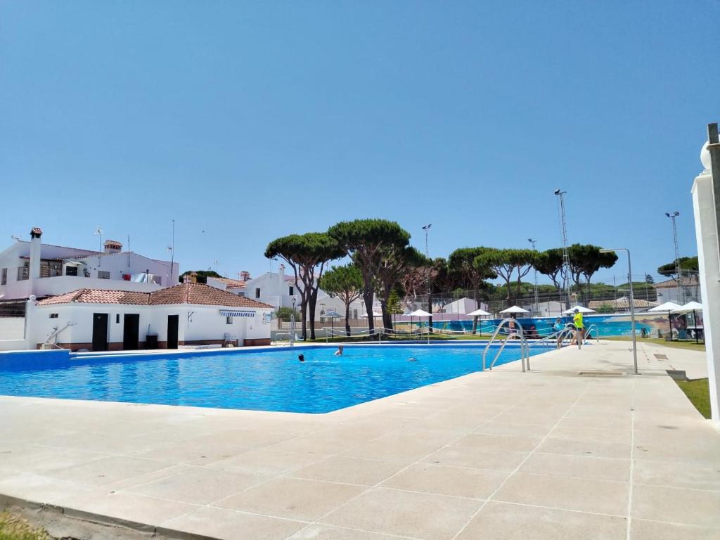 una piscina con una persona che pedala accanto ad essa di Duplex Las Torres La Barrosa 3Beds - A 700m de la playa a Chiclana de la Frontera