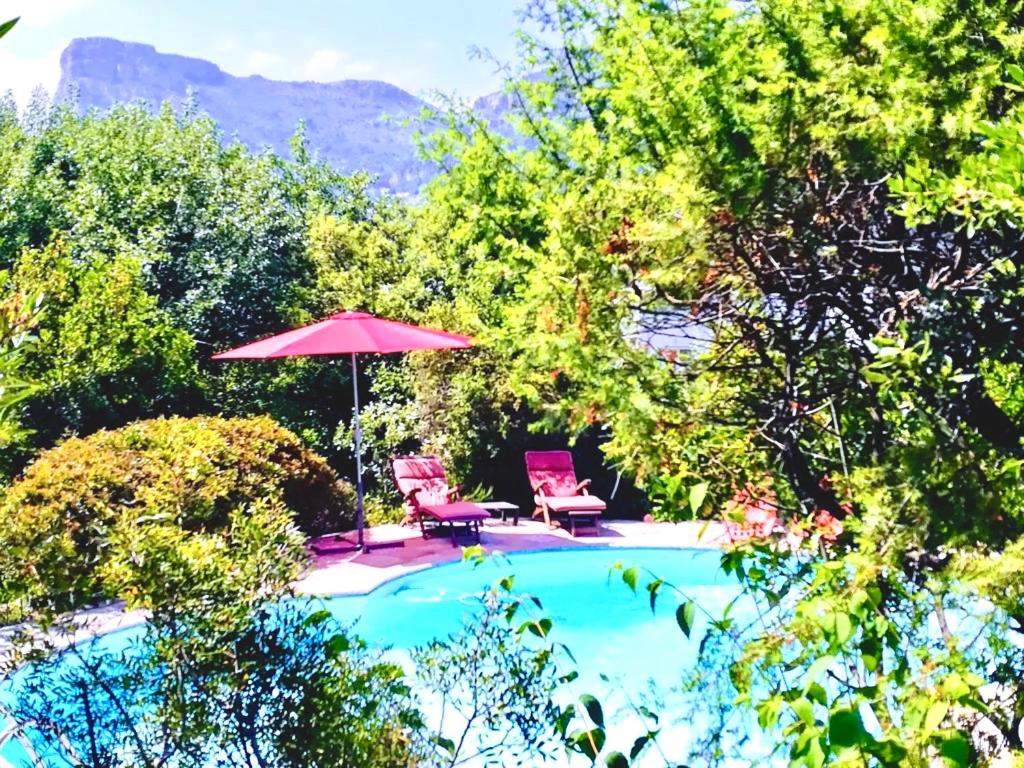 ラ・ゴードにあるVilla Côte d'Azur piscine privéeのスイミングプール(椅子2脚、パラソル付)