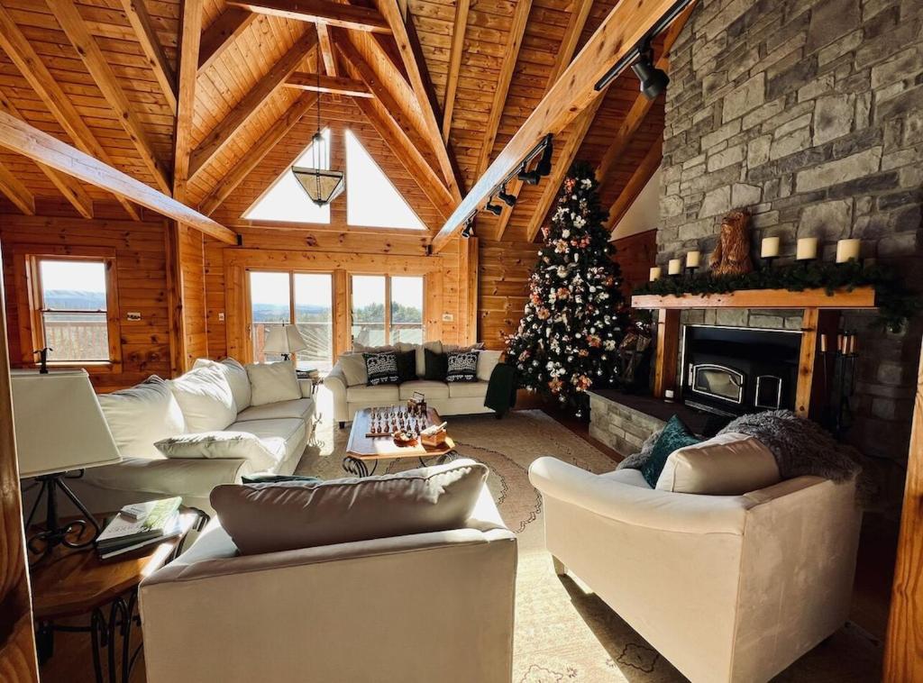 a living room with a christmas tree and a fireplace at Misty Mountains Lodge in Ronceverte