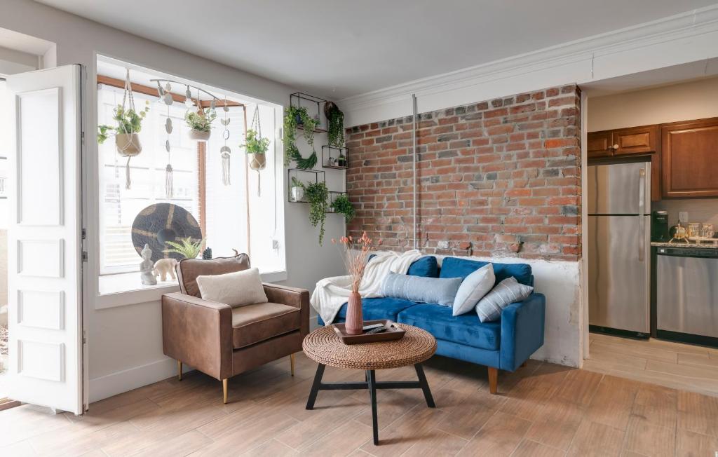 a living room with a blue couch and a brick wall at Prime Location! Cozy Home in Church Hill/Shockoe in Richmond