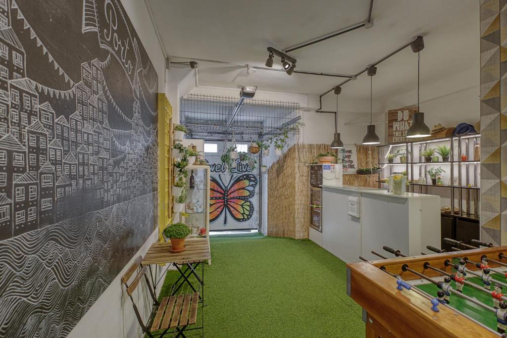 a kitchen with a chalkboard wall and green carpet at Travel & Live Porto Hostel in Porto