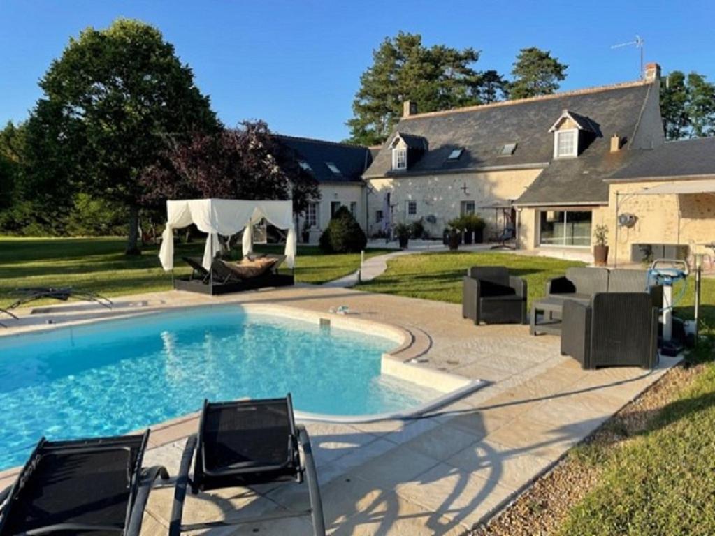 a swimming pool in front of a house at SUITE ROMANTIQUe in Cléré-les-Pins