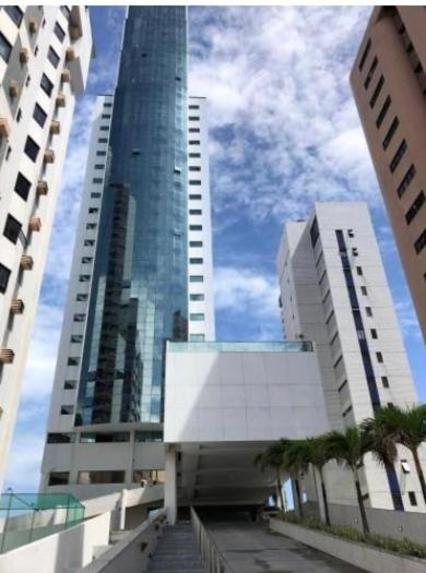 a tall building in a city with palm trees at BCE Home Stay in Recife