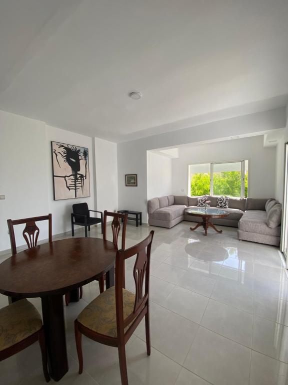 a living room with a table and chairs and a couch at Appartement de luxe en bord de mer à Skhirat Plage in Skhirat