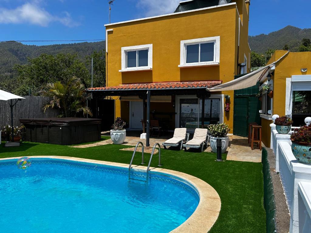 uma casa com piscina em frente a uma casa em TERRAZITA em Tijarafe