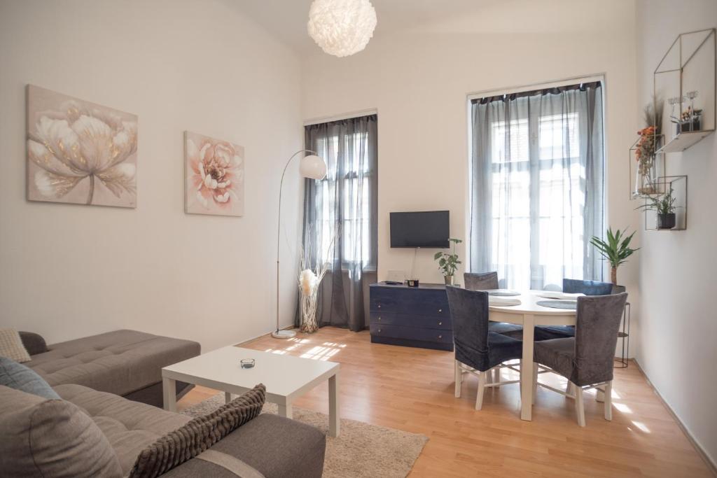 ein Wohnzimmer mit einem Sofa und einem Esstisch in der Unterkunft Magnolia apartment in Zagreb