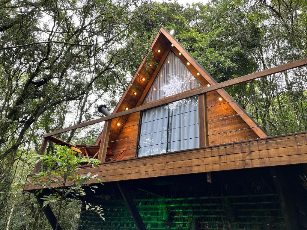 a tree house in the woods with a large window at Chalé da Roça - Garibaldi in Garibaldi