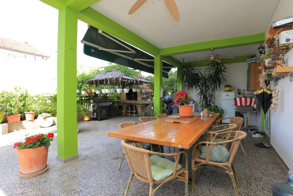 a patio with a wooden table and chairs at Apartments with parking space Gradac, Makarska - 2784 in Gradac