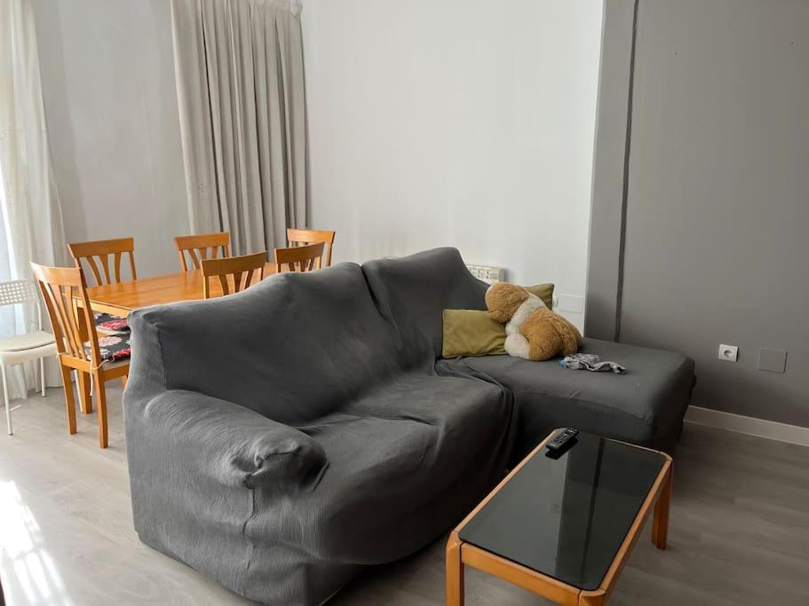 a teddy bear sitting on a couch in a living room at Piso céntrico in Medina del Campo