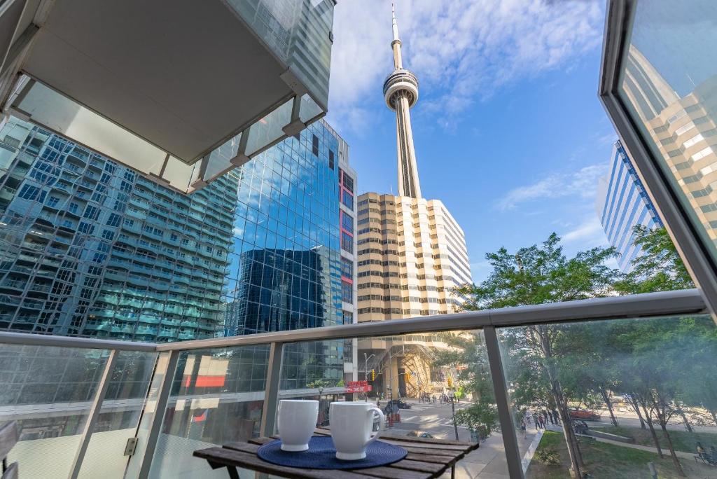 a balcony with a table and a view of the cn tower at Luxury 2BR Apt-CN View-Free Parking-Roof Top Pool in Toronto