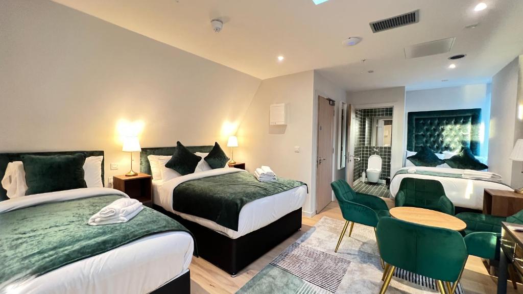 Cette chambre d'hôtel comprend deux lits, une table et des chaises. dans l'établissement Merrion Square Studios, à Dublin
