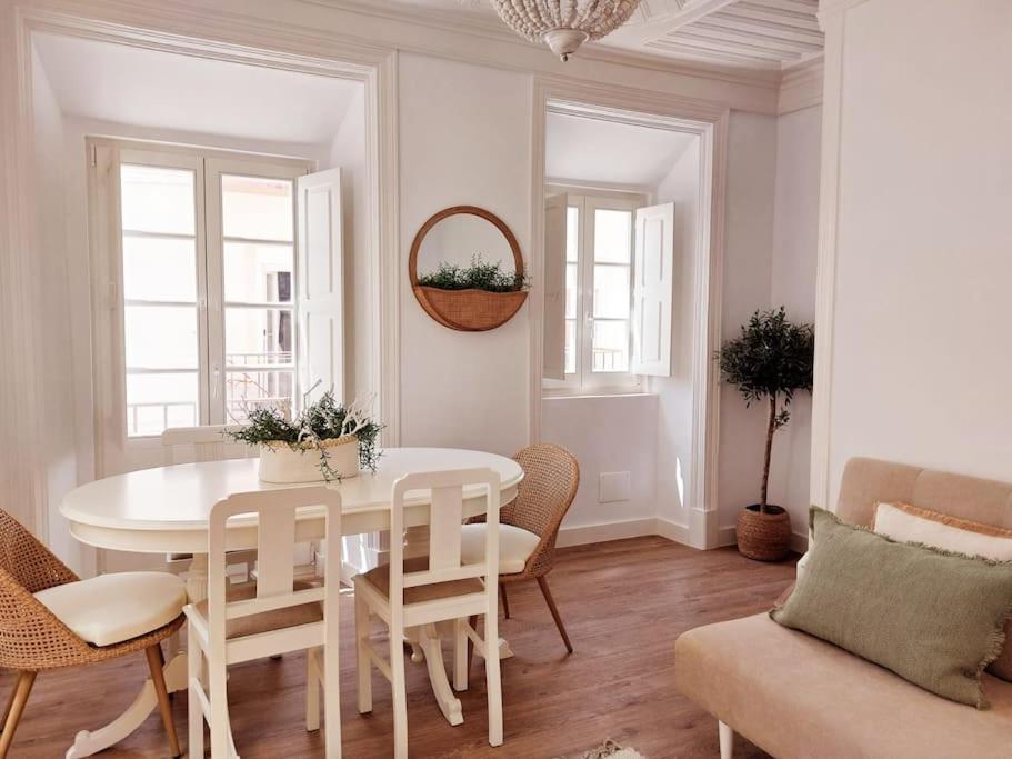 een witte eetkamer met een witte tafel en stoelen bij The Bird House in Nazaré