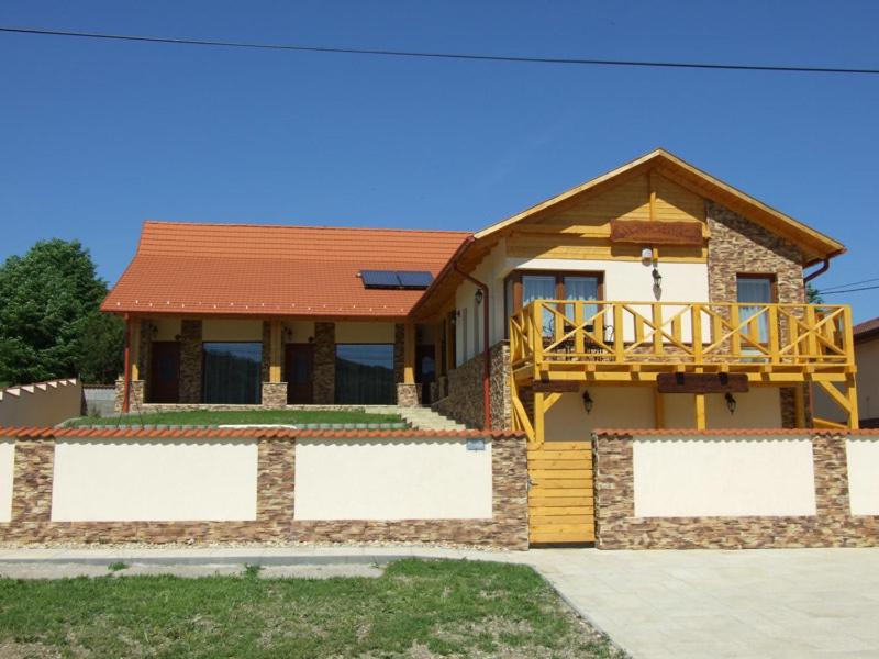 a house with a wooden deck on top of it at Vendégház Harsány in Harsány