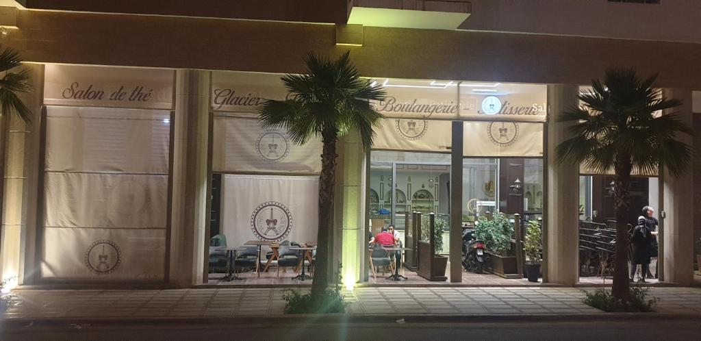 a store front with palm trees in front of it at Coralia Bel F3 clim wifi parking privé Iptv in Oujda