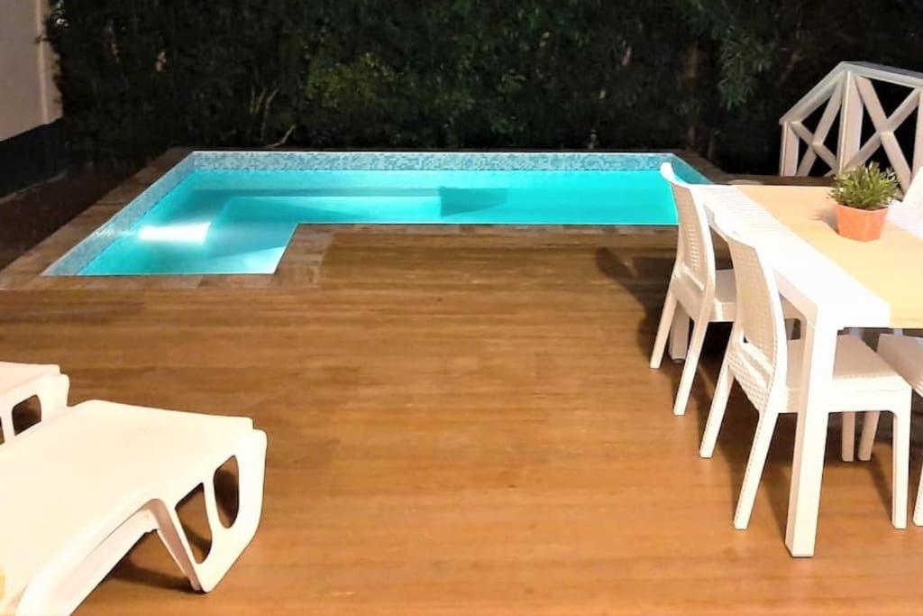 a pool with tables and chairs next to a pool at Vacation Home with Private Pool in Jolly Harbour