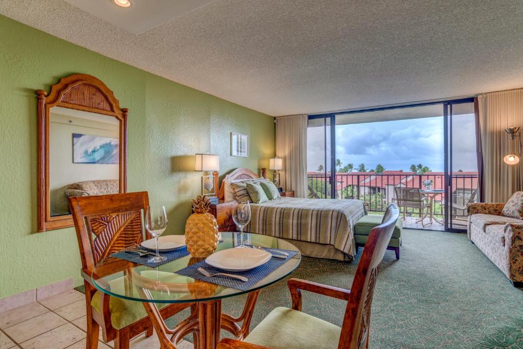 a living room with a table and a bed and a bedroom at Kaanapali Shores 640 in Kahana