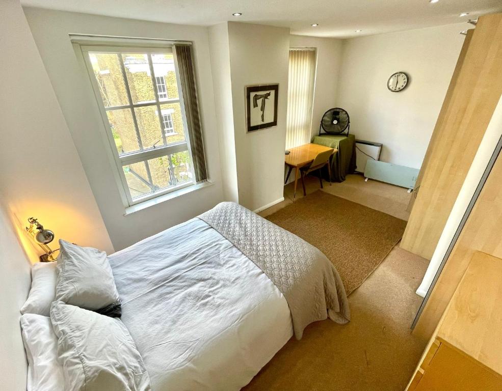 um quarto com uma cama branca e uma janela em Wilmot Guest House em Londres