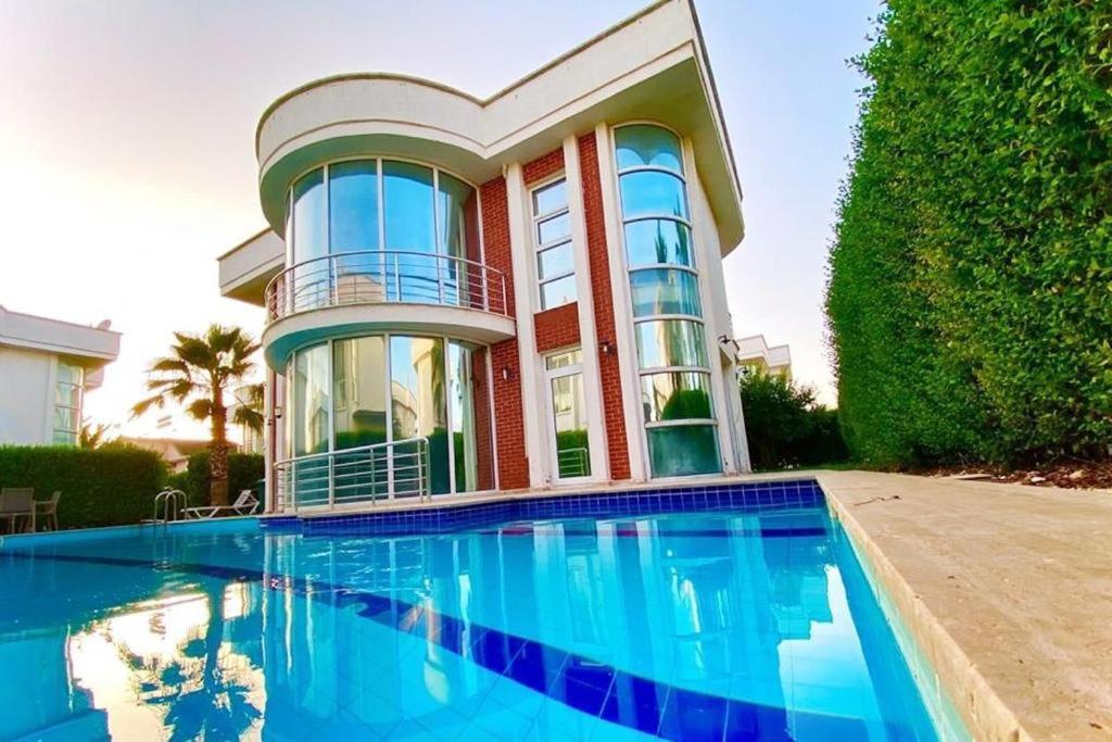 ein Haus mit einem Pool vor einem Haus in der Unterkunft ANTALYA BELEK HOLİDAY ViLLAS in Belek