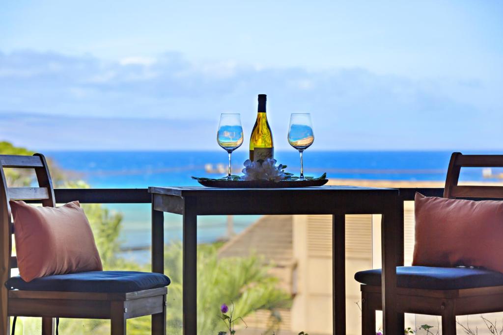 a table with two glasses and a bottle of wine at Kahana Villa F407 in Kahana