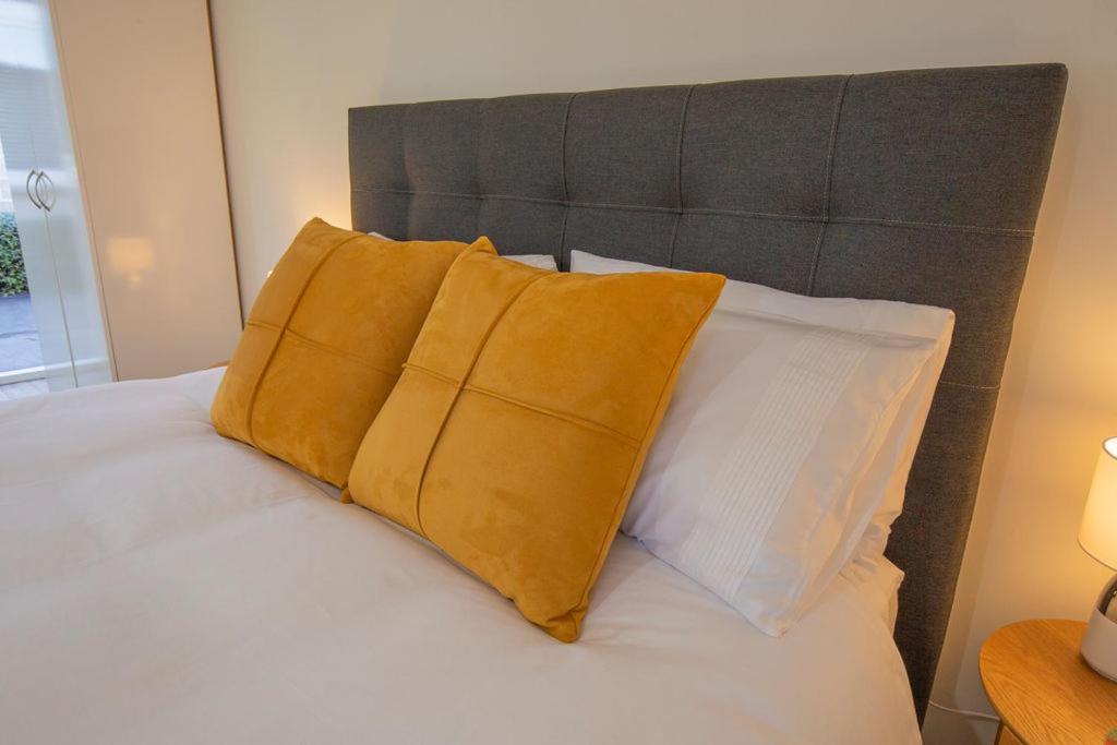 uma cama com duas almofadas amarelas em cima em Allen Street - Studio & Optional Private Sauna em Methven