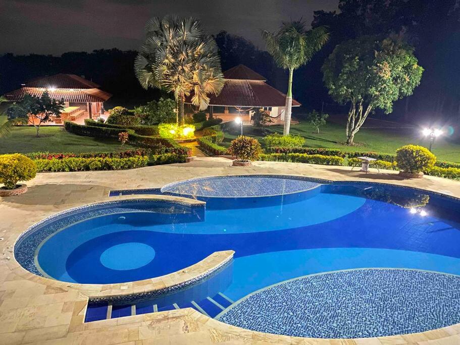 La mejor casa campestre a 25 min de Villavicencio في فيلافيسينسيو: حمام سباحة أزرق كبير في الليل