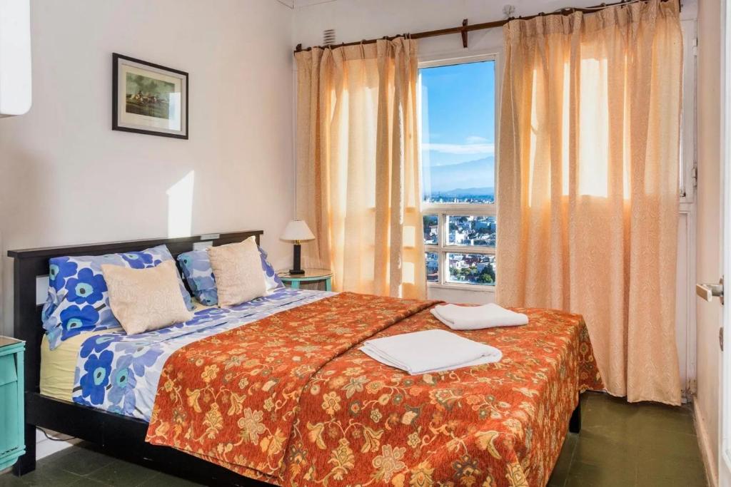 a bedroom with a bed and a large window at Balcones de Salta in Salta