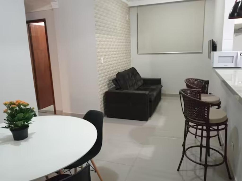 uma sala de estar com um sofá preto e uma mesa em Apartamento setor Bueno em Goiânia