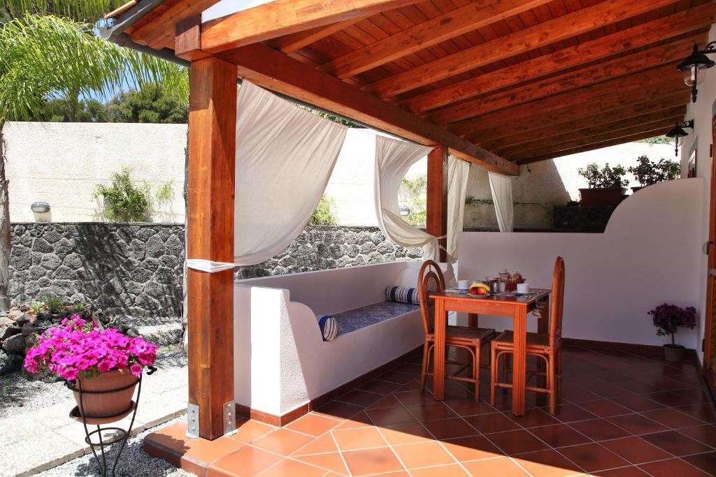 a room with a table, chairs, and a tub at Villa Crimi in Vulcano