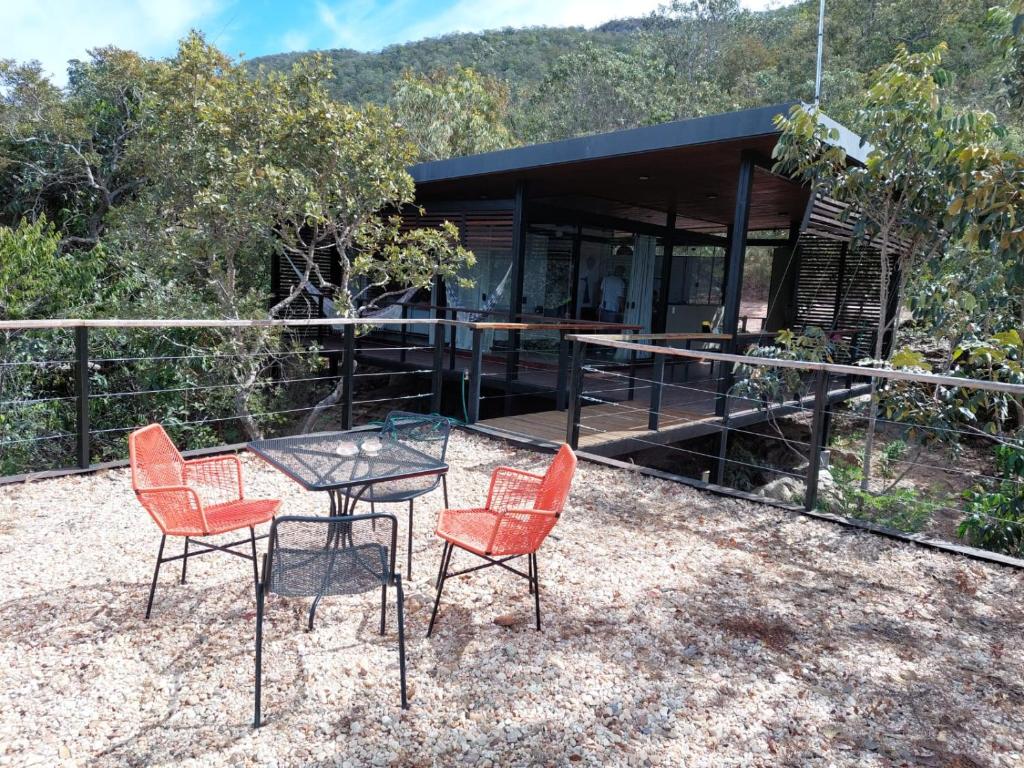 Casa da Serra في كافالكانتي: طاولة وكراسي يجلسون أمام المنزل