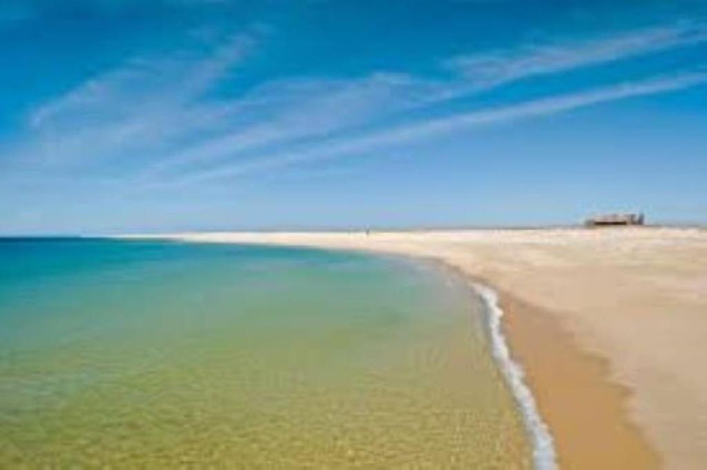 uma vista para uma praia com o oceano em The Islands em Faro