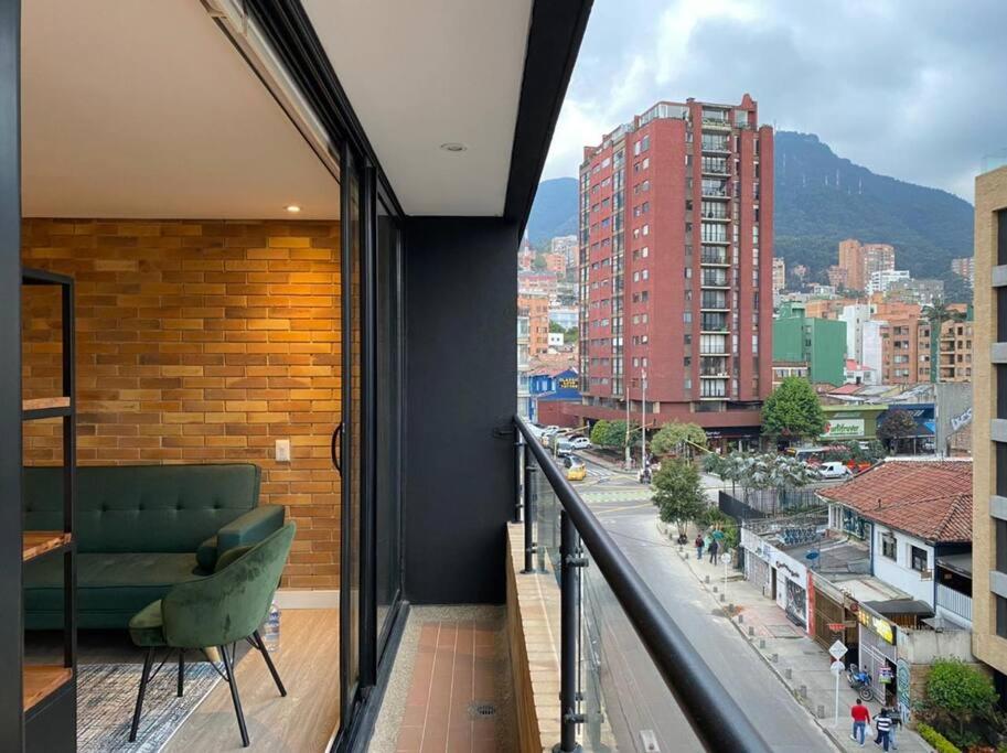 einen Balkon mit einem Sofa und Stadtblick in der Unterkunft 512 Sleek Haven Loft in Bogotá