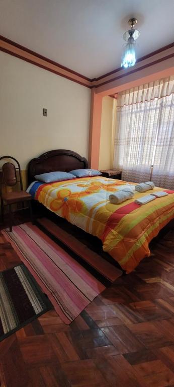 um quarto com uma cama com um edredão colorido em Hostal Sol y Luna em Copacabana