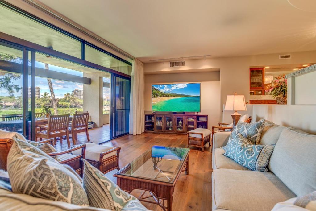 a living room with a couch and a tv at Kaanapali Royal D101 in Lahaina