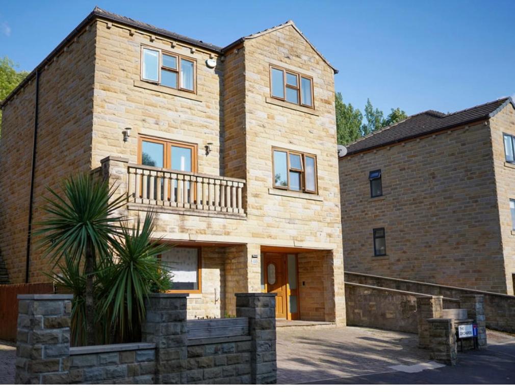 a large brick building with a balcony on it at House of Kaima - 6 bed detached in Dewsbury