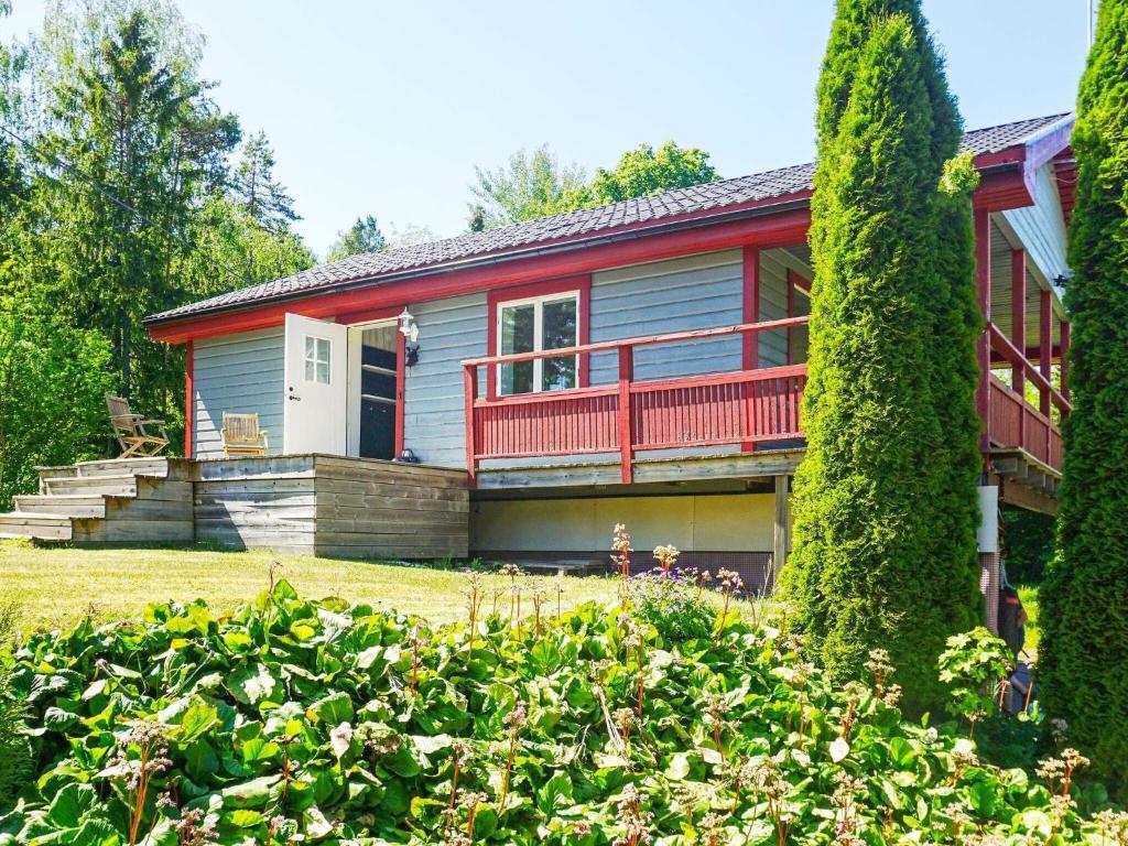 Hållnäs的住宿－Holiday home Hållnäs，一座带红色甲板和庭院的房子