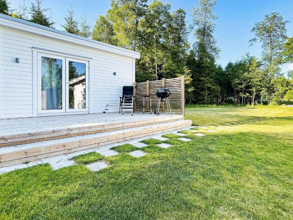 una casa con una terraza con una parrilla. en Holiday home LJUNGBY IV en Ljungby