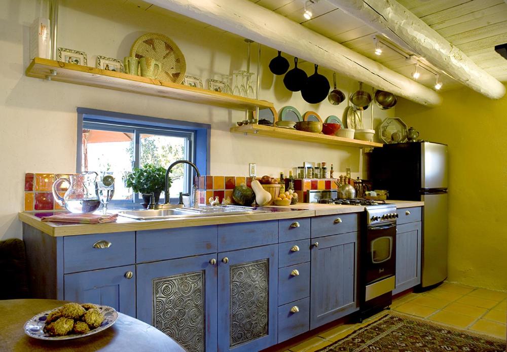 una cocina con armarios azules y fregadero en Casa Gallina - An Artisan Inn en Taos