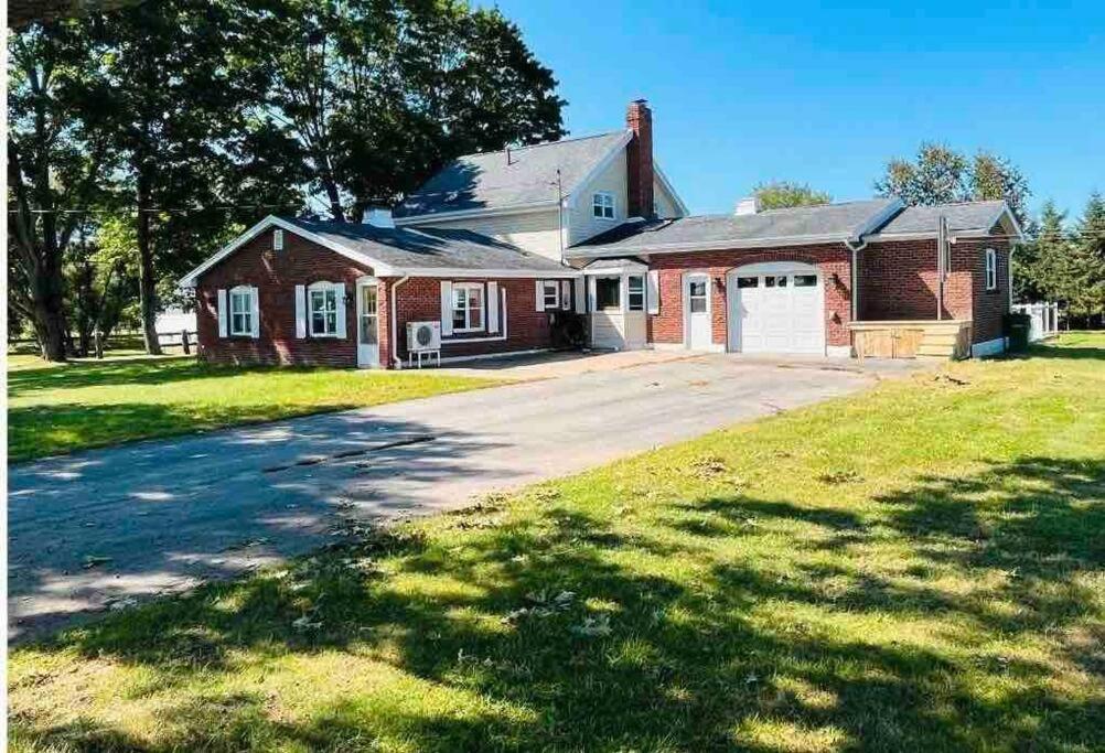 a red brick house with a garage and a driveway at Red Brick Farm House in Kentville