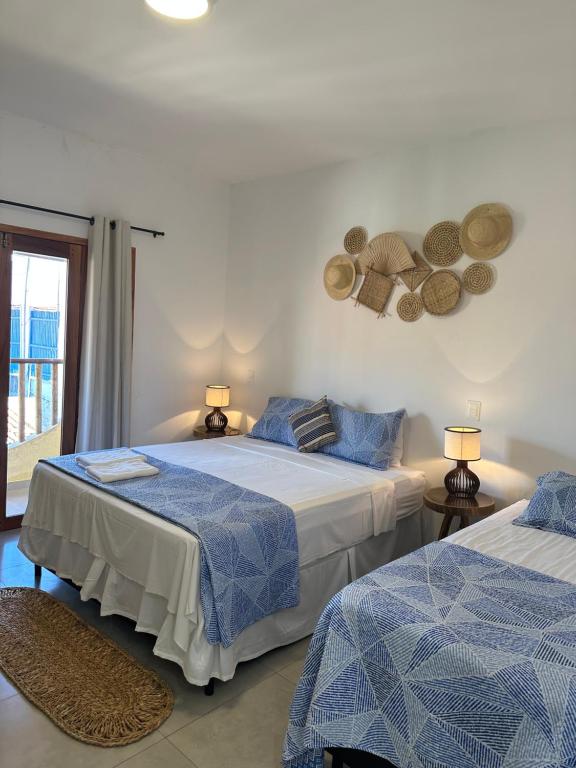 two beds in a room with blue and white at Villa Dom Felippe in Jericoacoara