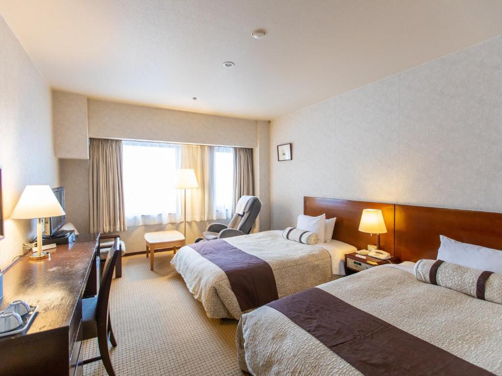 Postel nebo postele na pokoji v ubytování Kanazawa Kokusai Hotel