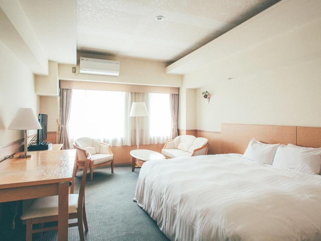 Postel nebo postele na pokoji v ubytování Kanazawa Kokusai Hotel