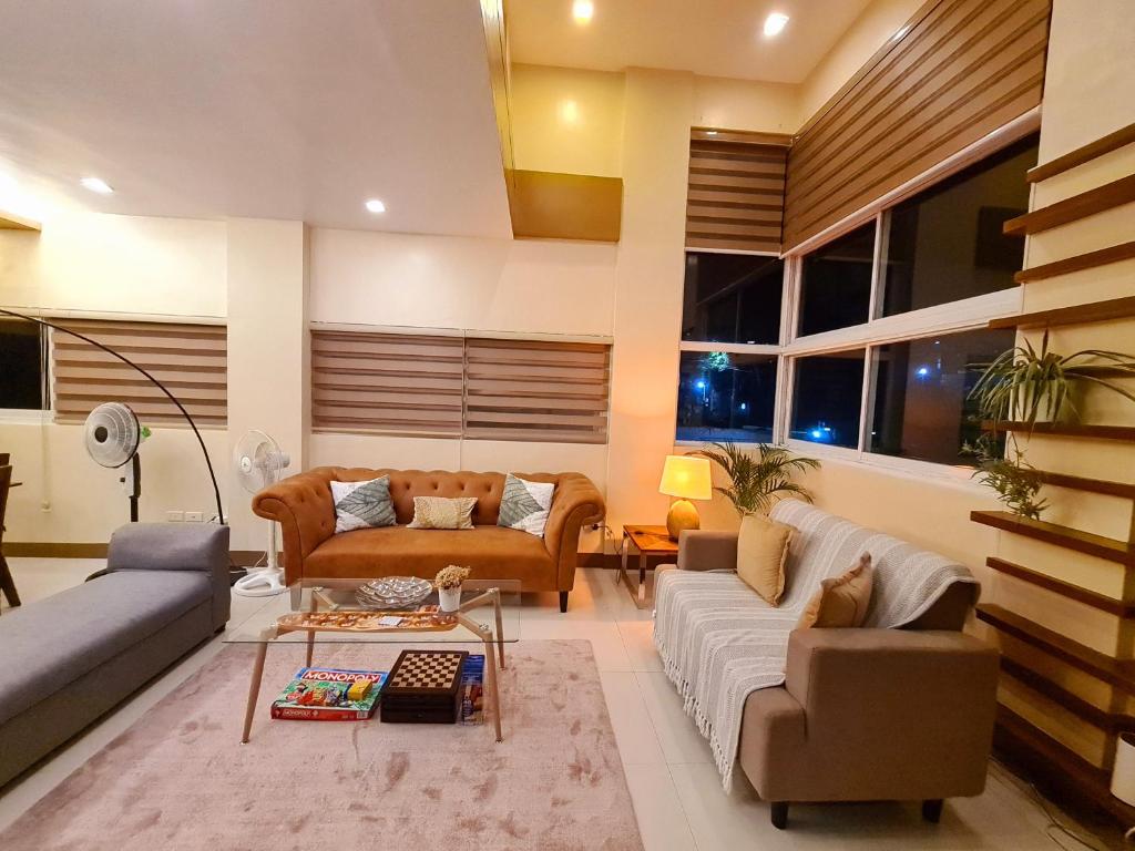 a living room with couches and a table at Serenity Home near Ayala Malls Serin in Tagaytay