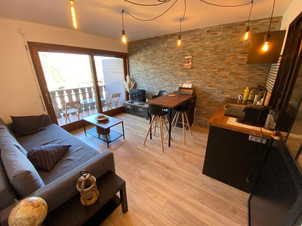 un salon avec un canapé et une cuisine avec une table dans l'établissement Studio Cabine Idéal: à 400m du Centre, Balcon Ouest, Casier à Skis – Châtel - FR-1-693-97, à Châtel
