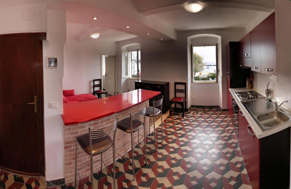 サン・テレンツォにあるCasa Floraのキッチン(赤いカウンター、いくつかの椅子付)
