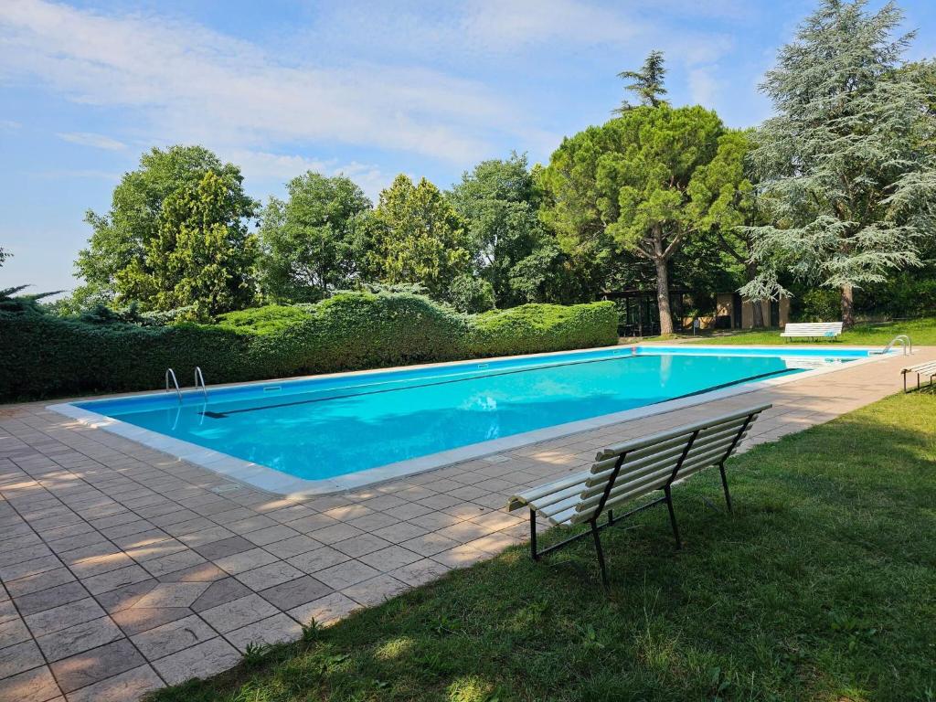 een zwembad met een bank in het gras bij Serene Holiday Home in Lazise with Swimming Pool in Lazise