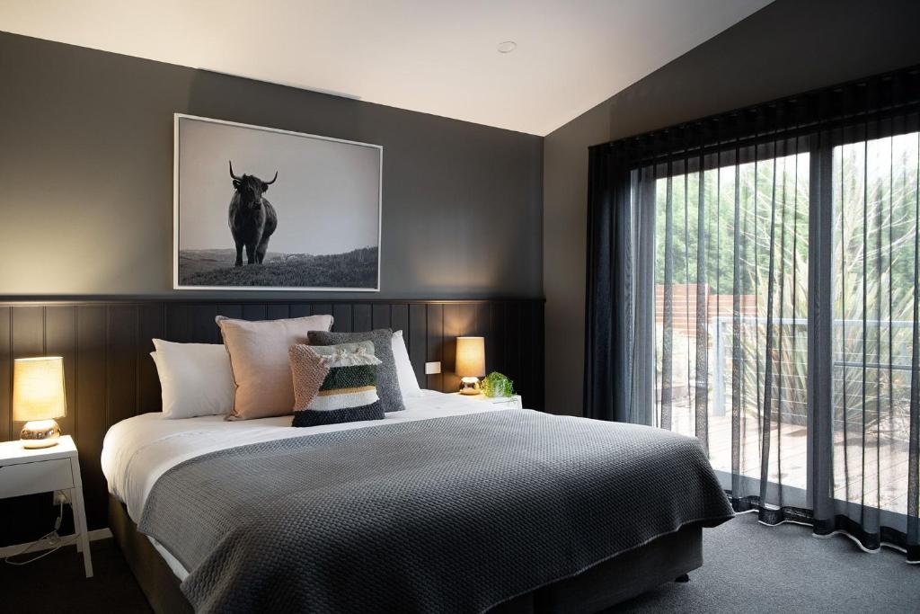 a bedroom with a bed with a picture of a cow on the wall at Delfryn in Daylesford