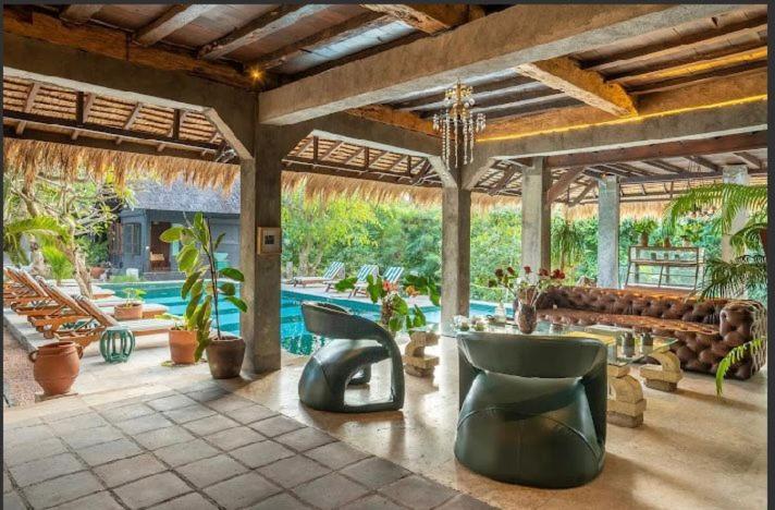 een grote patio met een bank en een zwembad bij The Corduroy Hotel in Canggu