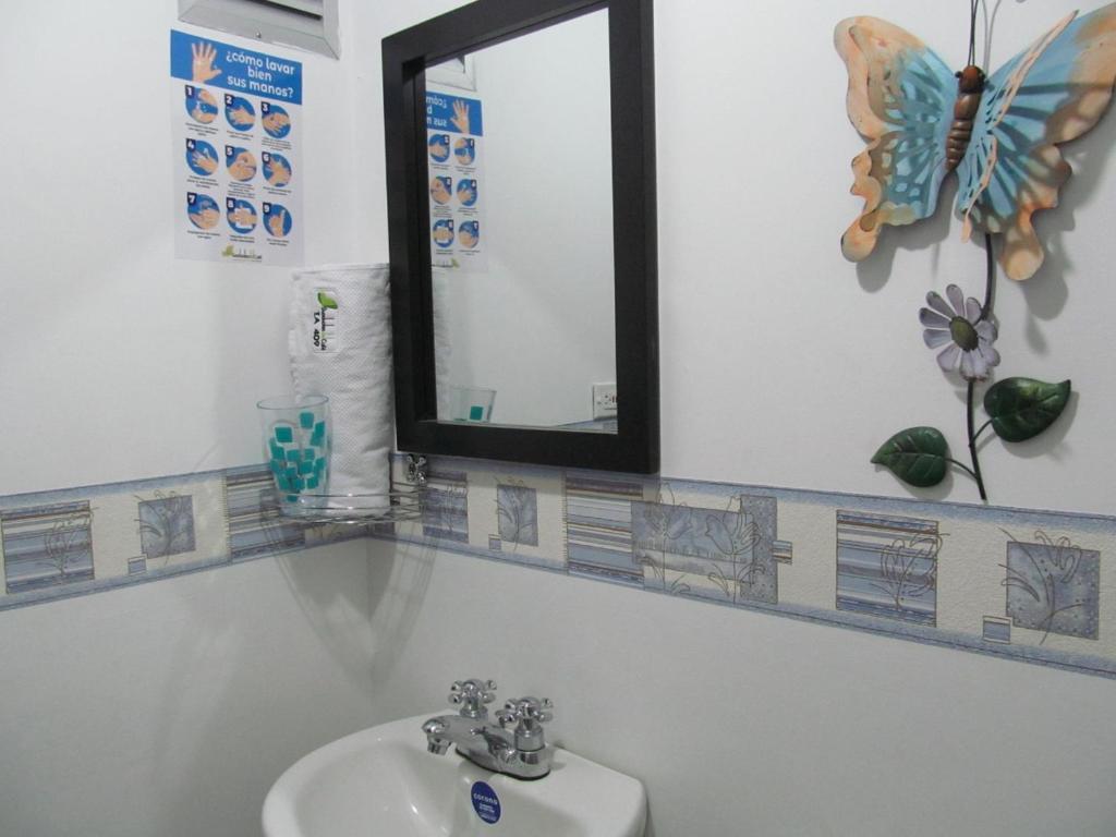 y baño con lavabo y espejo. en Lindos y cómodos Apartamentos en Guaduales del Café, en Montenegro