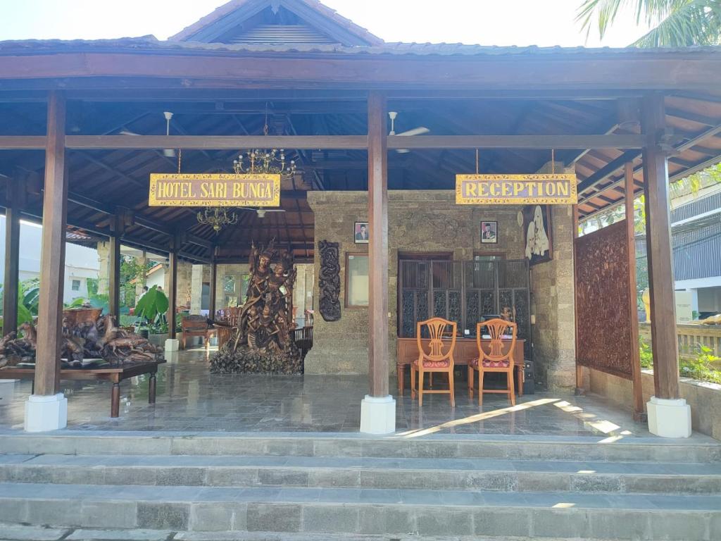 a building with two chairs and two signs on it at Hotel Sari Bunga in Legian