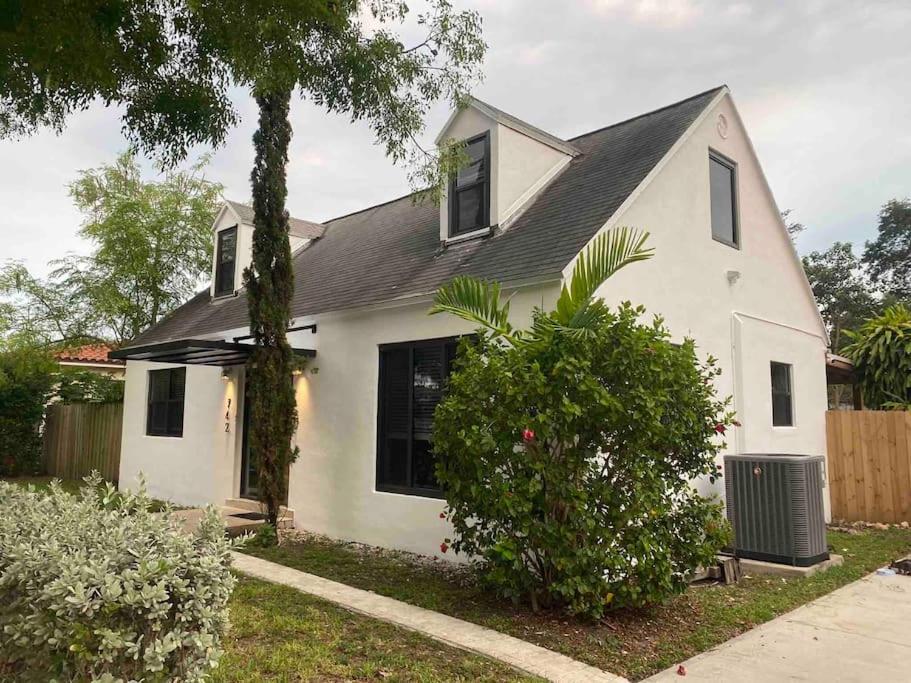 uma casa branca com um telhado preto em Cozy Chalet near the Design District em Miami